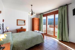a bedroom with a bed and a large window at Hostal y Apartamento Rural Los Naranjos in Melegis +46 photos