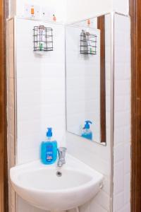 a bathroom sink with a mirror and blue soap at Cosy 1 Bedroom in CBD Mombasa with City View in Mombasa +16 photos