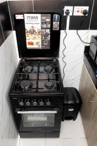 a gas stove in a kitchen next to a phone at Cosy 1 Bedroom in CBD Mombasa with City View in Mombasa