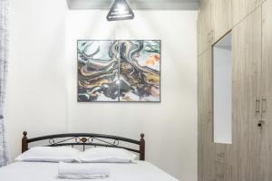 a bedroom with a bed and a painting on the wall at Cosy 1 Bedroom in CBD Mombasa with City View in Mombasa