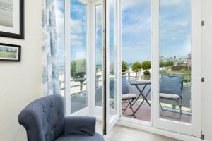 ein Wohnzimmer mit Glasschiebetüren, die auf einen Balkon führen in der Unterkunft Haus Windjammer Strandliebe in Laboe