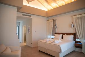 a bedroom with a large bed and a chair at Liberty Suites Spetses in Spetses