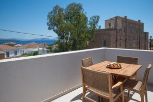 Una mesa y sillas en un balcón con vista. en Liberty Suites Spetses, en Spetses
