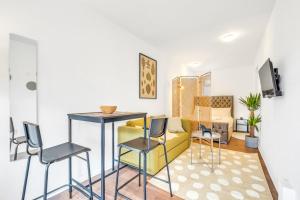 a living room with a table and chairs and a couch at 8 Private Rooms with own kitchen & bathroom, Parking, 30min to Wembley Stadium, sleeps 16 to 20 people in Colindale