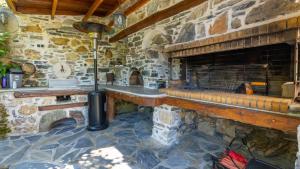 a stone fireplace with a bench in a stone building at Μountain Whispers in Mouresi
