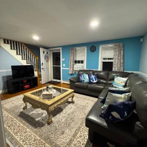 a living room with a leather couch and a coffee table at 5 bedroom farmhouse in sandwich cape cod in Sandwich