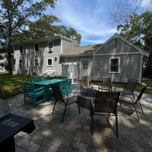 a patio with a ping pong table in front of a house at 5 bedroom farmhouse in sandwich cape cod in Sandwich +31 photos