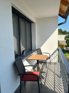 a patio with two chairs and a table on a balcony at Bodza Vendégház in Badacsonyörs