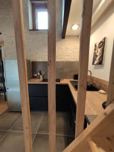 a kitchen with a counter with a sink and a refrigerator at Maison cosy au cœur du Marais Poitevin in Benet +18 photos