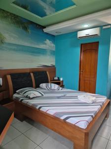 a bed in a room with a blue wall at papillon hotel in Sao Paulo