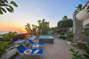 een patio met stoelen en een zwembad en de oceaan bij Villino La Canfora in Ischia
