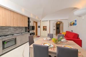 een keuken en een woonkamer met een tafel en een rode bank bij Villino La Canfora in Ischia