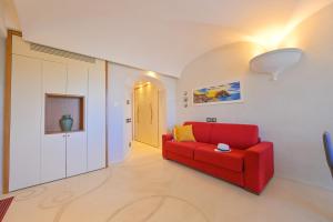 een woonkamer met een rode bank en een hal bij Villino La Canfora in Ischia +23 foto's