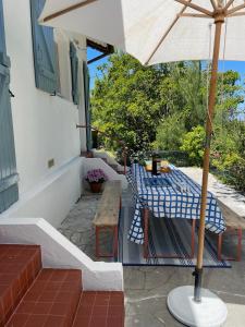 a table with an umbrella on a patio at Maison entre Landes et Pays basque, Plage à 3km in Ondres