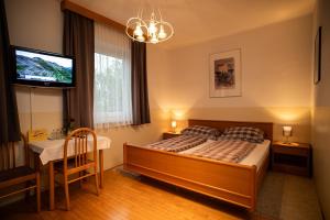 a bedroom with a bed and a table and a television at Gasthaus-Gostišče-Trattoria Ogris in Ludmannsdorf +50 photos