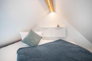 a small attic bedroom with a bed and a pillow at Tinyhaus Supreme für 1-4 Personen in Fuchsmühl