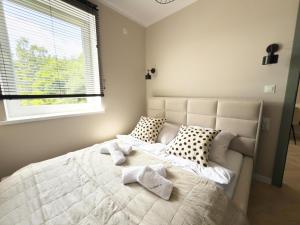 a bedroom with a large bed with pillows and a window at Apartamenty przy Dworcu by LibertaRent in Wałbrzych
