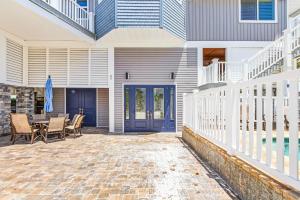 a patio with a table and chairs in front of a house at Luxury Beach Front Pool Home in Paradise! home in Fort Myers Beach +56 photos
