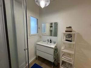 a white bathroom with a sink and a mirror at L'étape Aixoise - appartement climatisé terrasse parking centre ville Rotonde cours Mirabeau allées provençales in Aix-en-Provence +13 photos