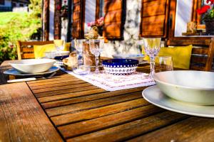a wooden table with bowls and glasses on it at Da Bino - Vicino Pista Ciclabile in Valle di Cadore