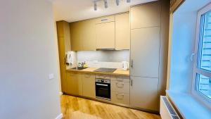 a kitchen with yellow cabinets and a sink and a stove at Apartamenti Pētera 28 in Ventspils +17 photos