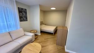 a living room with a couch and a bed at Apartamenti Pētera 28 in Ventspils