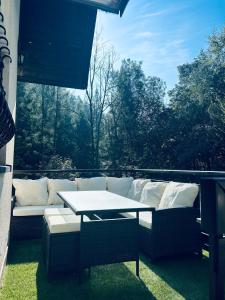 - un canapé blanc et une table sur la terrasse dans l'établissement Ostoja przy potoku- z tarasem oraz parkingiem- BestRooms, à Międzybrodzie Żywieckie