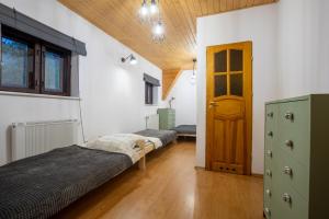 - une chambre avec 2 lits et une porte dans l'établissement Ostoja przy potoku- z tarasem oraz parkingiem- BestRooms, à Międzybrodzie Żywieckie
