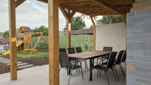 een patio met een tafel en stoelen en een speeltuin bij Yellow House in Comarnic