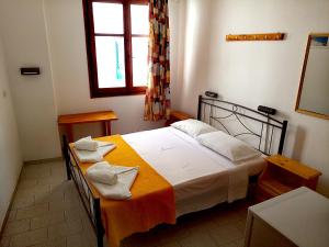 A bed or beds in a room at To Gefyraki Rooms