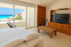 a bedroom with a bed and a television and a table at Beach Front Condos in Hotel Zone in Cancún