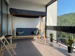 a porch with a blue couch on a balcony at Forest View Apartment in Rogača