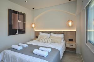 Un dormitorio con una gran cama blanca con dos almohadas. en Holi Top Luxurious Apartment, en Ierápetra