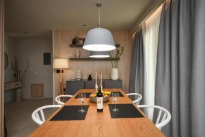 Un comedor con una mesa de madera con copas de vino. en Holi Top Luxurious Apartment, en Ierápetra