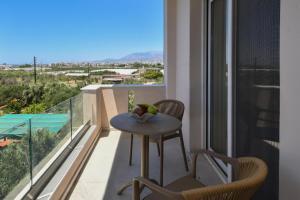 Una mesa y sillas en un balcón con vista. en Holi Top Luxurious Apartment, en Ierápetra