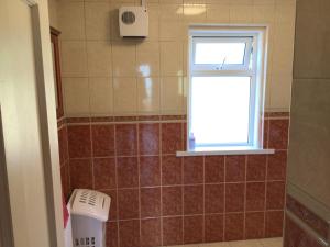 ein Badezimmer mit einem Fenster und einem Mülleimer in der Unterkunft Swilly View House in Ramelton + 19 Fotos
