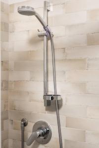 einen Duschkopf im Bad mit Ziegelwand in der Unterkunft Interludio Fiorentino in Florenz + 25 Fotos