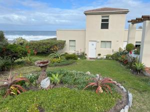 赫曼努斯Oceans Edge - Hermanus Beach Club的海滨带花园的房子