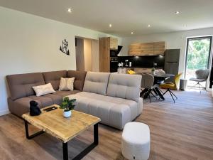 a living room with a couch and a table at L'écrin du Ferrand in Le Dévoluy