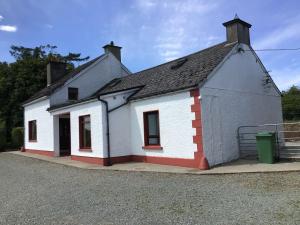 ein kleines weißes Gebäude mit schwarzem Dach in der Unterkunft Swilly View House in Ramelton