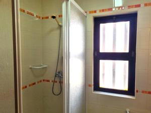 a bathroom with a shower and a window at CASA DO SOL by Stay in Alentejo in Vila Nova de Milfontes +6 photos