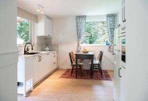 a kitchen with white cabinets and a table with chairs at Mandala Źródła Natury SPA in Wierzchy Kluckie