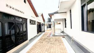 ein Gehweg zwischen zwei Gebäuden mit einer Tür in der Unterkunft Kigali White home in Kigali