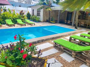 a swimming pool with chaise lounge chairs and a resort at Ondo House in Nungwi