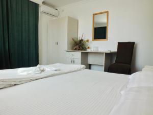 a bedroom with a bed and a desk and a chair at Hotel Trio Giroc in Giroc