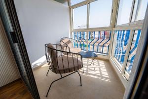 two chairs and a table in a room with windows at Modern & Central 2BR Stay in Rabat in Rabat