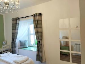 a bedroom with a window and a bed and a chandelier at Killarney central apartments in Killarney +1 photo