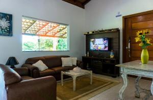 グアペにあるCasa Linda Alecrim do Campo em Capitólio - MGのソファとテレビのあるリビングルーム