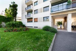 a building with a green lawn in front of it at Appartement COCON Balcon et Clim - Lyon Part-Diev - Dreamy Flat Lyon in Lyon