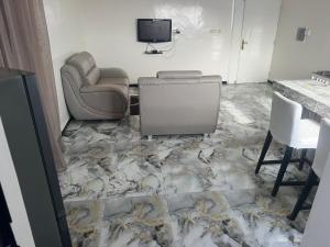 a room with a couch and a chair and a television at Studio meublé Saint Louis Sénégal in Saint-Louis